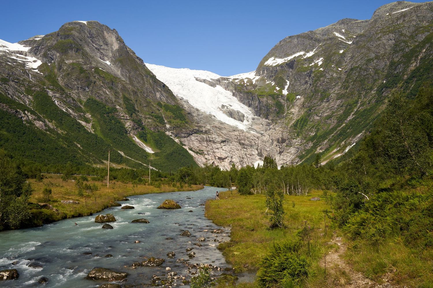 Breelv som renner ut fra en bretunge i en fjelldal