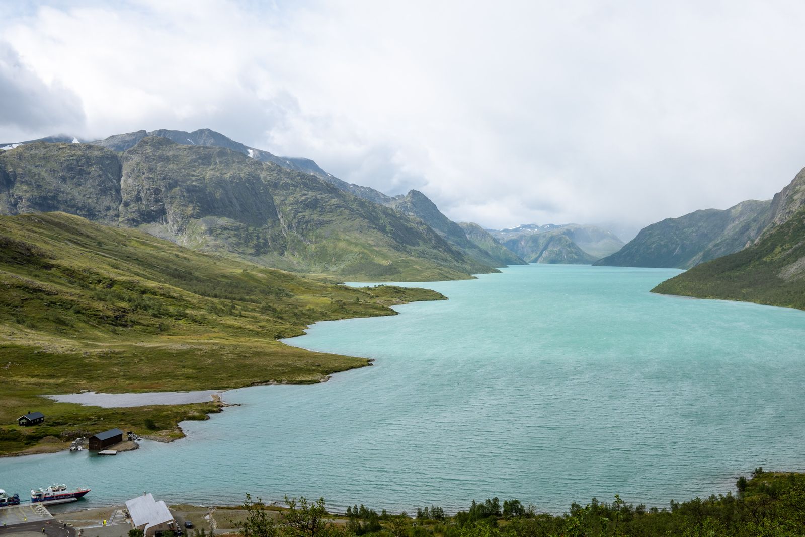 Turkist fjellvann omgitt av høye fjell